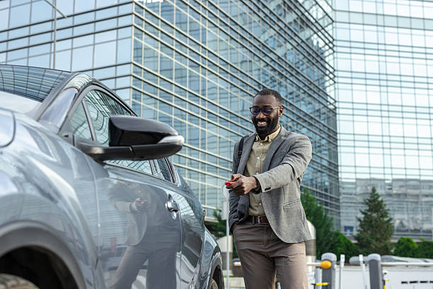istock Smiling man unlocking a car in an urban environment 2229973521