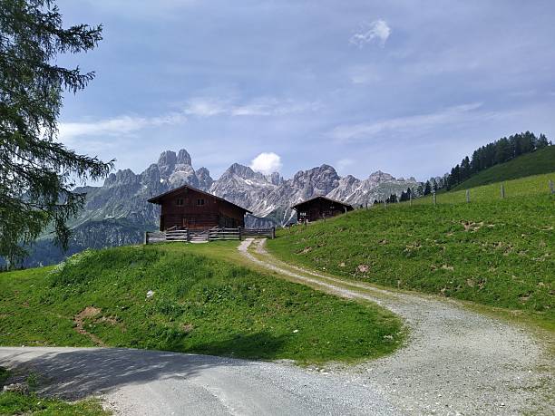 istock Alpine Mountain Cabins on Green Hillside with Panoramic Peaks 2229973592