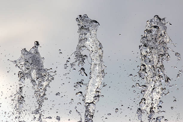 istock Fountain water splashes create stunning patterns under gray sky during a sunny day 2229978368