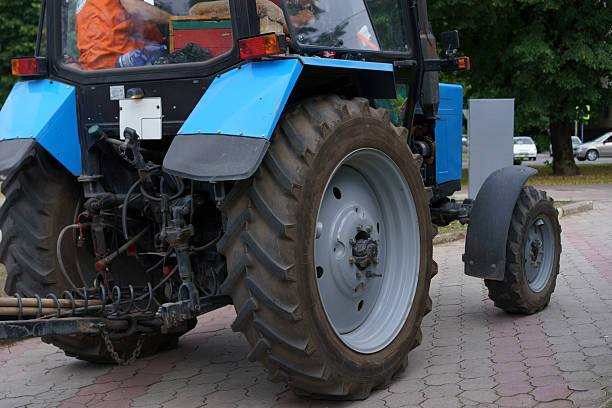 female farmer portrait in front of farm equipment.