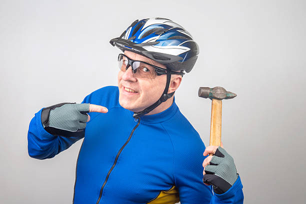 istock Cyclist in a blue outfit holding a hammer with a playful expression and protective gear 2229978629