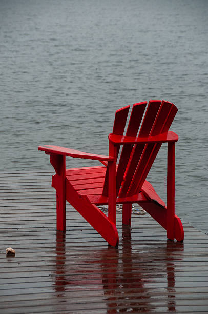 istock A single red Adirondack chair on a wet dock 2229979353
