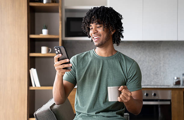 istock Happy man at home looking at his cell phone on his coffee break 2229982673