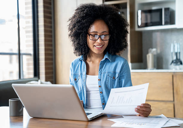 Happy African American young woman smiling while working at home -  telecommuting concepts