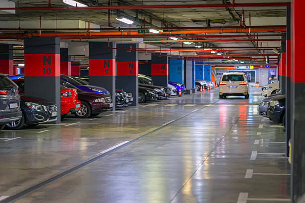 istock Spacious underground parking lot with marked spaces, cars parked in rows, bright lighting. Concept of underground parking, urban infrastructure, modern city facility 2229983579