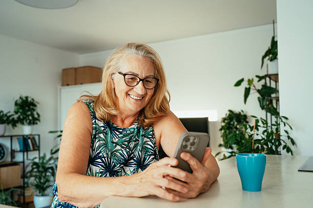 istock Healthy senior woman using technologies at home - smart phone, laptop and digital tablet 2229983685