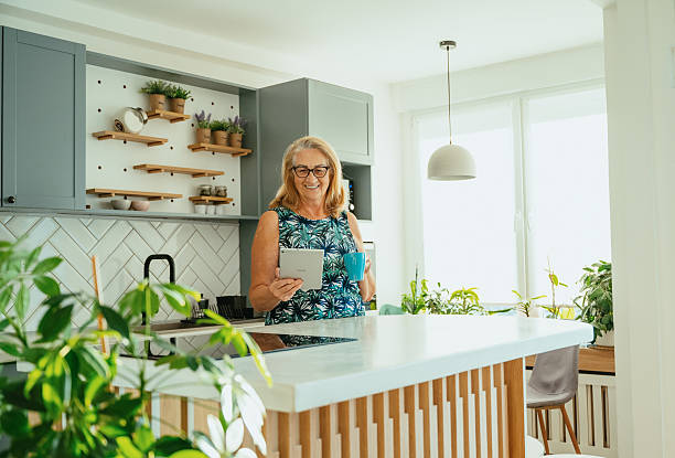 istock Healthy senior woman using technologies at home - smart phone, laptop and digital tablet 2229983689