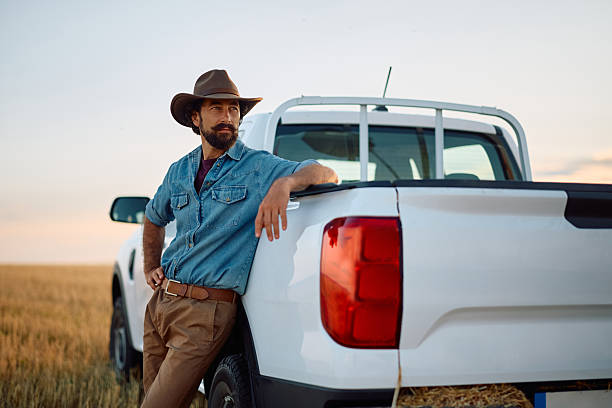 istock Pensive leaning on a pick-up truck while standing in the field. 2229985733