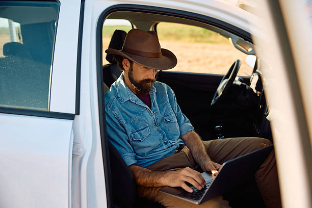 istock Farmer in pick-up truck working on a laptop. 2229986055
