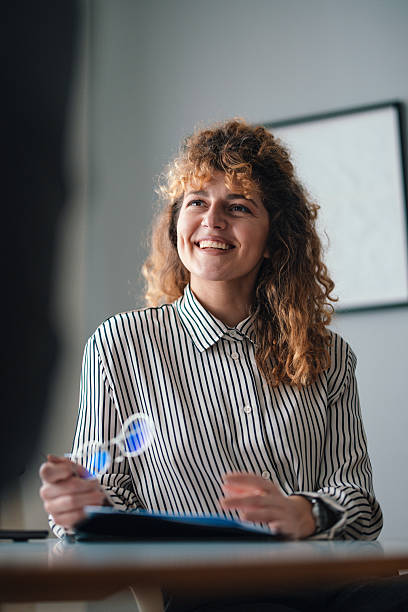 istock Smiling Professional Woman Holding Glasses in a Modern Office Setting 2229986859