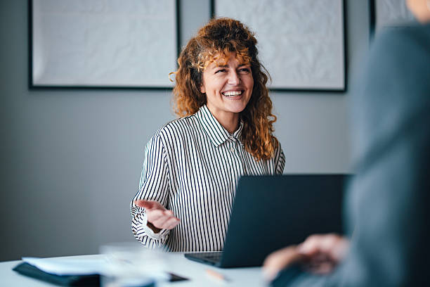 istock Smiling Professional Woman in Office During Work Discussion 2229986864