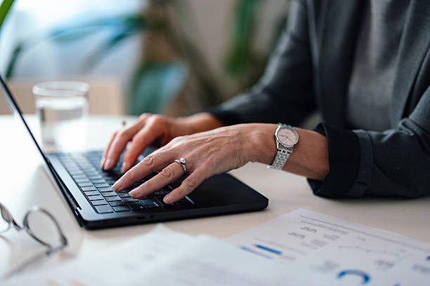 istock Professional Businessperson Typing on Laptop in a Modern Office Environment 2229986879