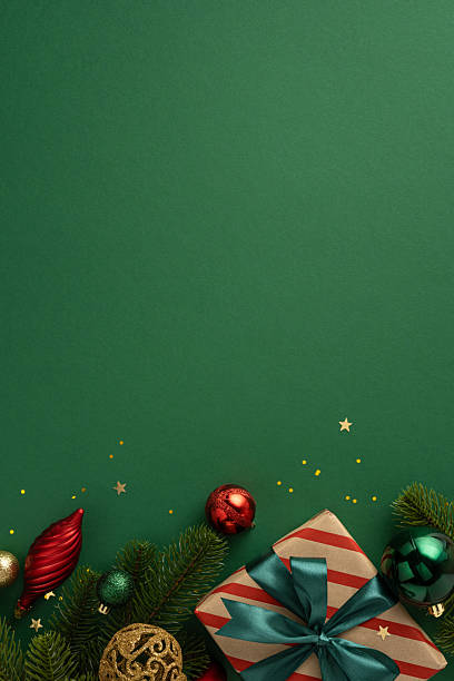 istock Christmas-themed vertical decorations and gift-wrapped present with festive colors on a green surface 2229990249