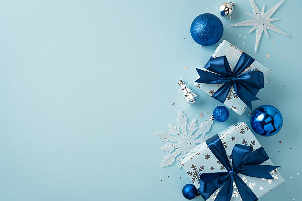 istock Elegant gift-wrapped boxes adorned with blue bows accompanied by festive silver and blue ornaments 2229990259