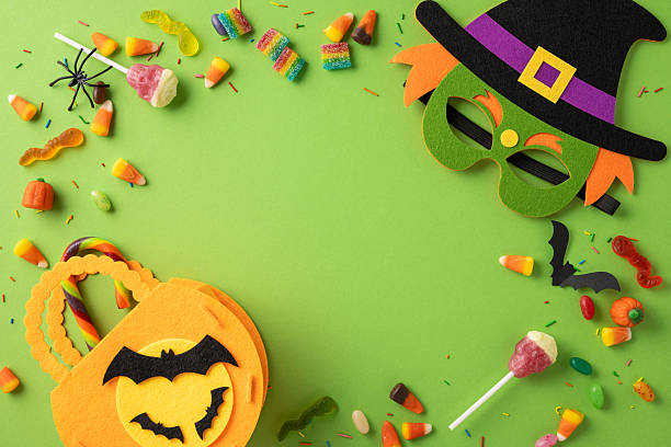 istock Brightly colored candy and Halloween-themed decorations arranged creatively on a vibrant green surface 2229990274