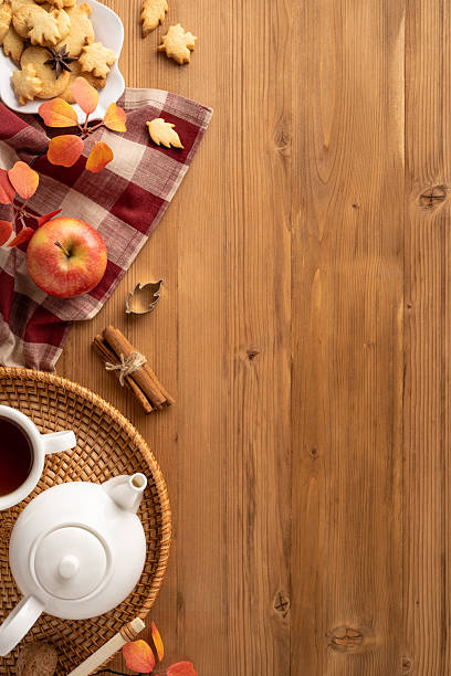 istock Warm vertical autumn-inspired composition featuring tea, cookies, apples, and decor on a rustic table 2229990355