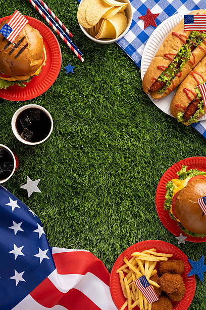 istock Labor Day or Independence Day celebration featuring a picnic vertical setup with classic American food items like burgers, hotdogs, fries, and patriotic elements against a grass background 2229990360