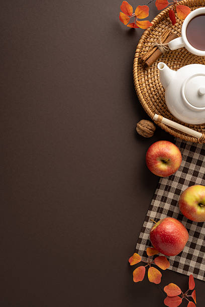 istock Autumn-inspired vertical tabletop setup featuring a tea pot, apples, cinnamon sticks, and fallen leaves 2229990380