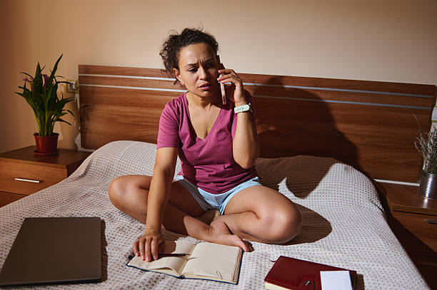 istock Woman Working Remotely While Talking on Phone in Cozy Home Interior 2229994603