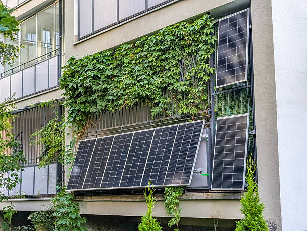 istock Eco-friendly residential building facade featuring solar panels and green ivy growing on modern architecture 2229996064