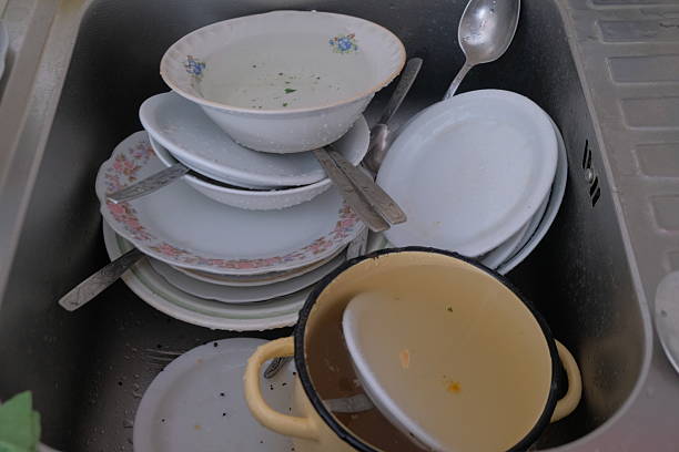 Dirty dishes different in the sink before cleaning spoons plates pots 1
