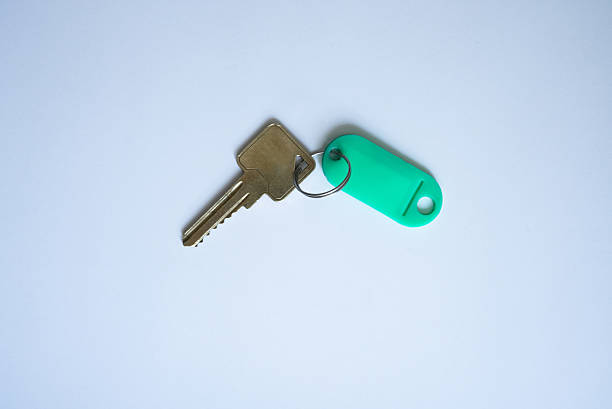 House key with green keychain on white background. Blank keychain