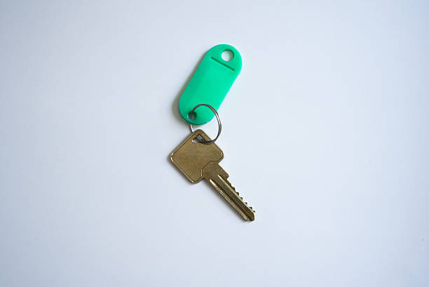 New house keys sit on a wooden counter.
