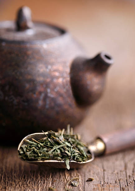 Organic green tea sencha with rustic old spoon and teapot