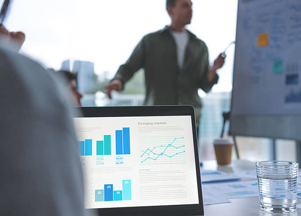 istock Business people watching a presentation on the whiteboard. A man is writing on the whiteboard with charts and graphs 2230003069
