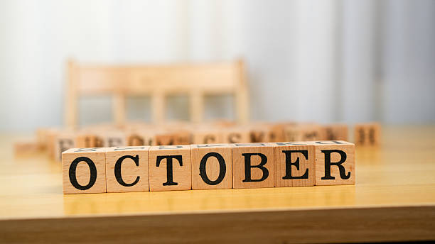 istock October is represented with wooden blocks on table, creating warm and inviting atmosphere. background is softly blurred, emphasizing focus on word 2230004842