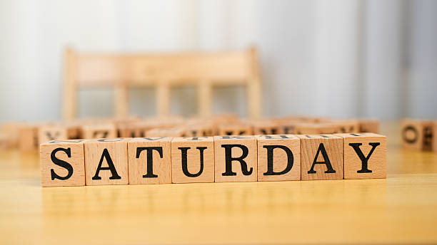 istock Saturday blocks arranged on wooden table create cheerful atmosphere, symbolizing relaxation and leisure. warm tones of wood enhance inviting feel of scene 2230004866