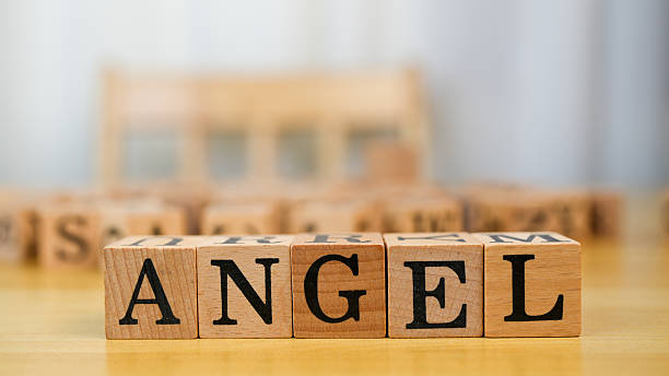 istock Wooden blocks spelling word ANGEL on table, creating warm and inviting atmosphere. soft focus background adds serene touch to scene 2230004882