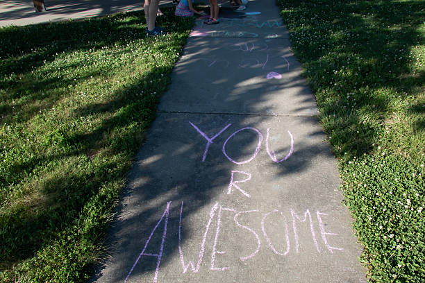 Sidewalk Chalk Message 'You R Awesome' with Children's Feet