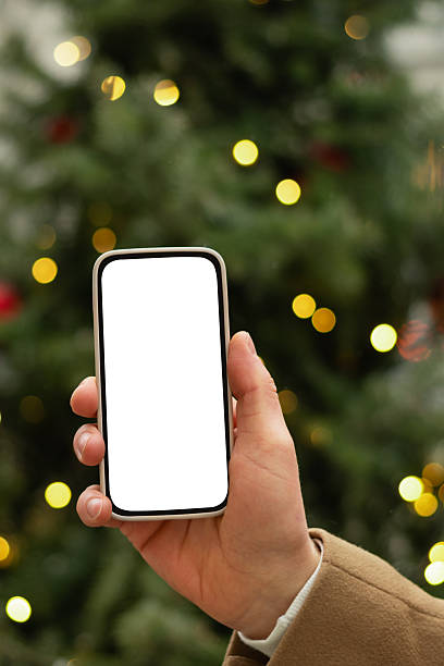 istock Man hand with smartphone near Christmas tree light garland. 2230008843