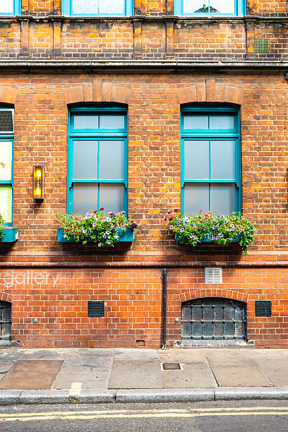 istock Flower boxes adorning a brick building in london 2230014082