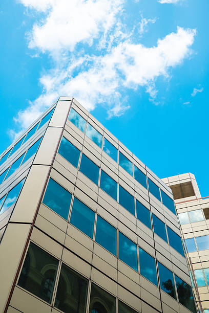 istock Modern office building reflecting blue sky and clouds in london 2230014203