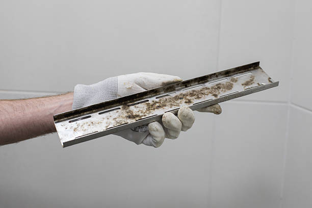 istock Plumber holding Stained Water Drain on Gray Background 2230015203