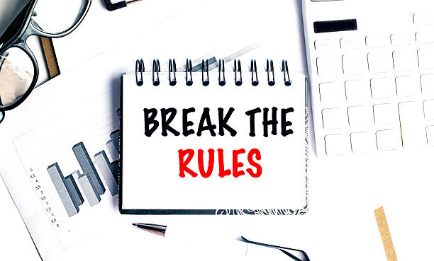 istock Notepad with break the rules text on desk with charts, glasses, keyboard and pen 2230026154