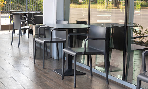 istock Modern Outdoor Cafe Seating with Black Chairs and Glass Reflections 2230038720