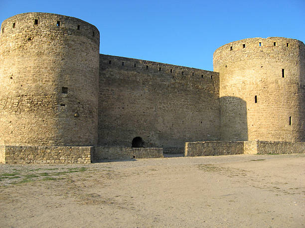 istock Medieval stone fortress with massive round defensive towers under clear blue sky, representing ancient military architecture, cultural heritage, and historic fortification design 2230046443