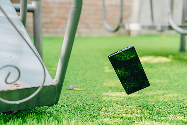 Cell phone is seen falling onto the ground, with its screen and back part damaged and cracked.