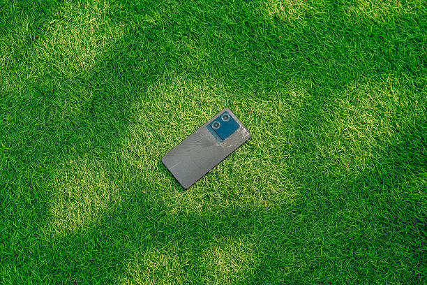 Cracked cell phone laying on the ground.