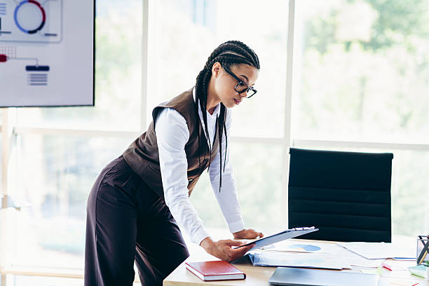 istock Confident businesswoman in formal attire analyzing data at an office desk 2230062399