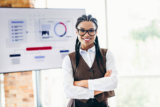 Confident businesswoman in formal attire standing in a modern office with a digital interface behind her