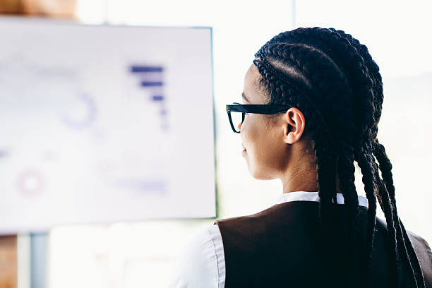 istock Professional businesswoman presenting analytics during corporate meeting in modern office environment with screen 2230062453