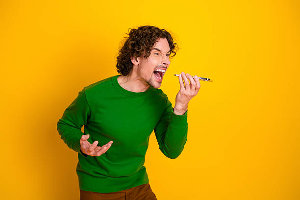Cheerful young man talking through a tin can phone isolated on white background