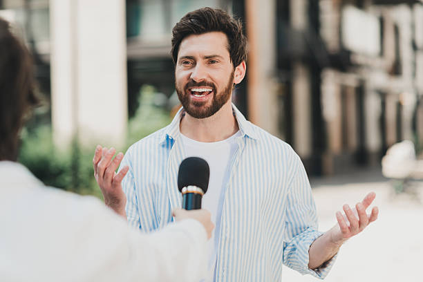 istock Young man being interviewed outdoors in a sunny urban area expressing thoughts confidently 2230066151