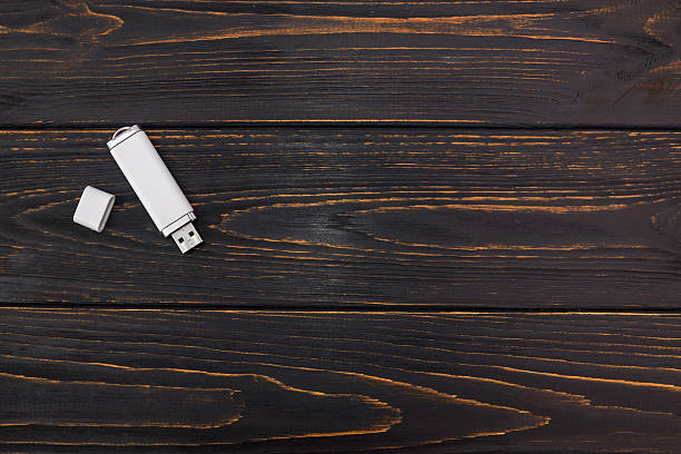 white flash drive on wood background with copy space. View from above. Flat lay.