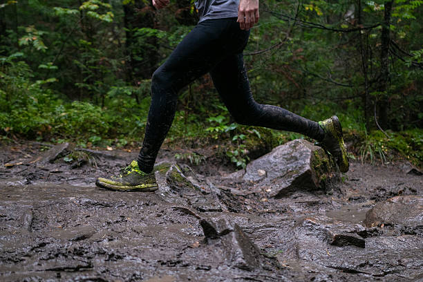 istock Legs athlete running mud and rocks during forest marathon 2230068330