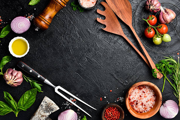 istock Background of the barbecue. Meat fork, kitchen utensils, salt, pepper and spices on table surface. Free space for text. Top view. 2230070920
